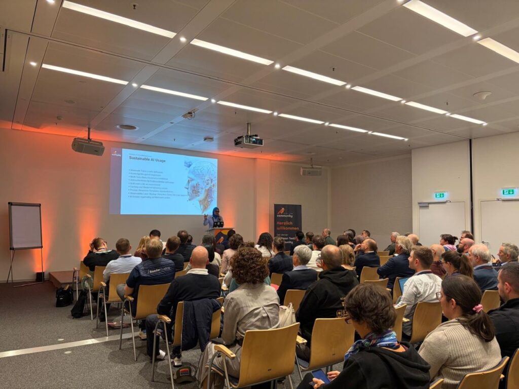 Lilia Gargouri, Head of QA at mgm technology partners, speaks in front of an audience about sustainable AI Usage in software development.